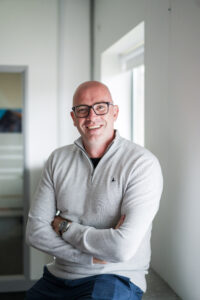 Headshot of Nexus Chief Technical Officer, Peter Ennis, on a blurred office background